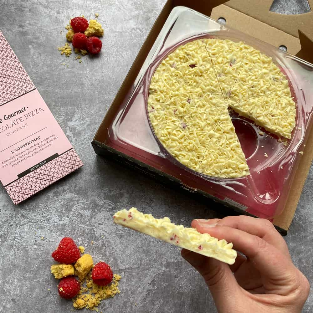Sweet raspberries and amaretti biscuits are set into the solid white chocolate base of our Raspberrymac Chocolate Pizza.